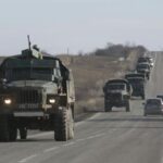 Fighters with the separatist self-proclaimed Donetsk People’s Republic army ride in the back of a truck towing a mobile artillery cannon as they leave the frontline, and head toward Donetsk