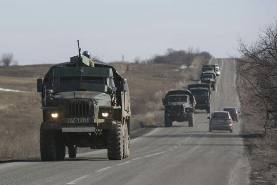 Fighters with the separatist self-proclaimed Donetsk People’s Republic army ride in the back of a truck towing a mobile artillery cannon as they leave the frontline, and head toward Donetsk