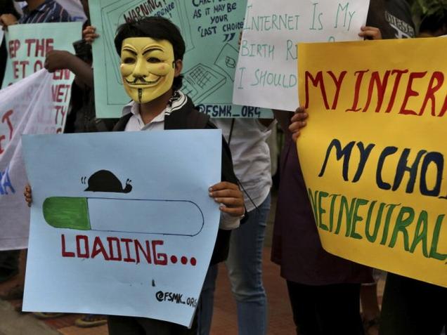 An activist wears a mask as he holds a placard during a demonstration supporting net neutrality, in Bangalore – AP