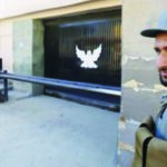 An Afghan policeman guards the gate of a guesthouse after an attack the previous night in which 14 civilians were killed, in Kabul, May 14, 2015.