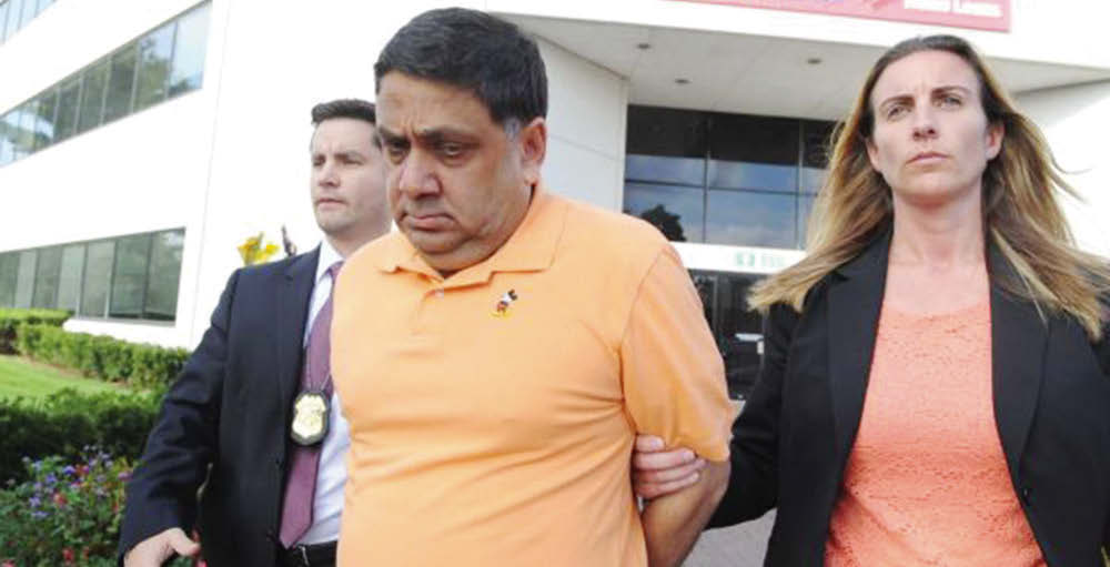 Harendra Singh is led out of the FBI office in Melville early Wednesday