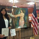 Anu Jain poses with her award in front of her entries in the exhibition