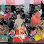 Hindu and Sikh families wait for lunch inside a Gurudwara in Kabul