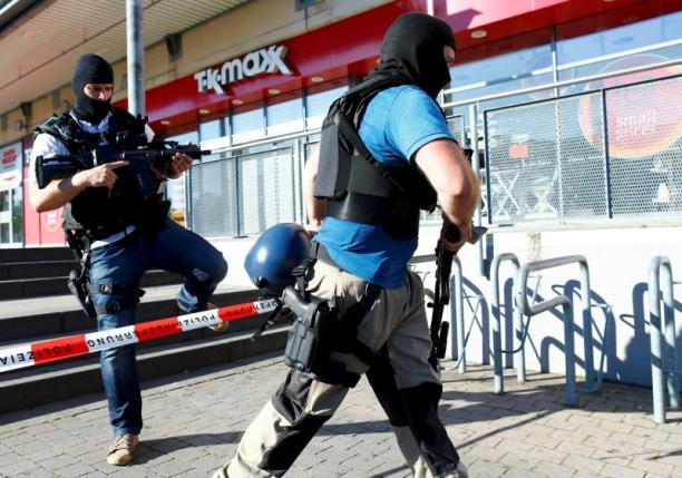 German special police walks past a cinema complex after a masked man with a gun and ammunition belt opened fire in Viernheim