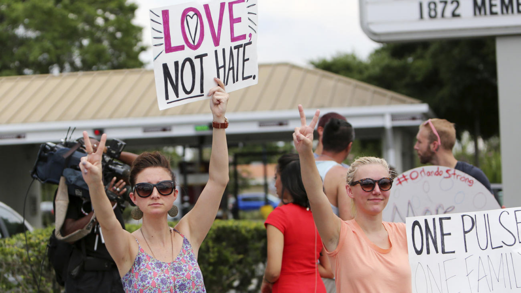 People hold signs in support of the Orlando shooting victims on Sunday. (Copyrights Jacob Langston / Orlando Sentinel)