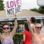 People hold signs in support of the Orlando shooting victims on Sunday. (Copyrights Jacob Langston / Orlando Sentinel)