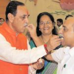 Gujarat Chief Minister Vijay Rupani and Deputy Chief Minister Nitin Patel share sweets at CMO before taking charge as the Gujarat Chief Minister at Gandhinagar on Monday. - Image - PTI