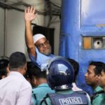 Jamaat-e-Islami party leader, Mir Quasem Ali waves his hand as he enters a van at the International Crimes Tribunal court in Dhaka on November 2, 2014. PHOTO: AFP