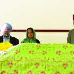 Consul General of India in New York, Riva Ganguly Das, flanked by gurdwara representatives, stands behind Guru Granth Sahib at a Gurdwara in Connecticut