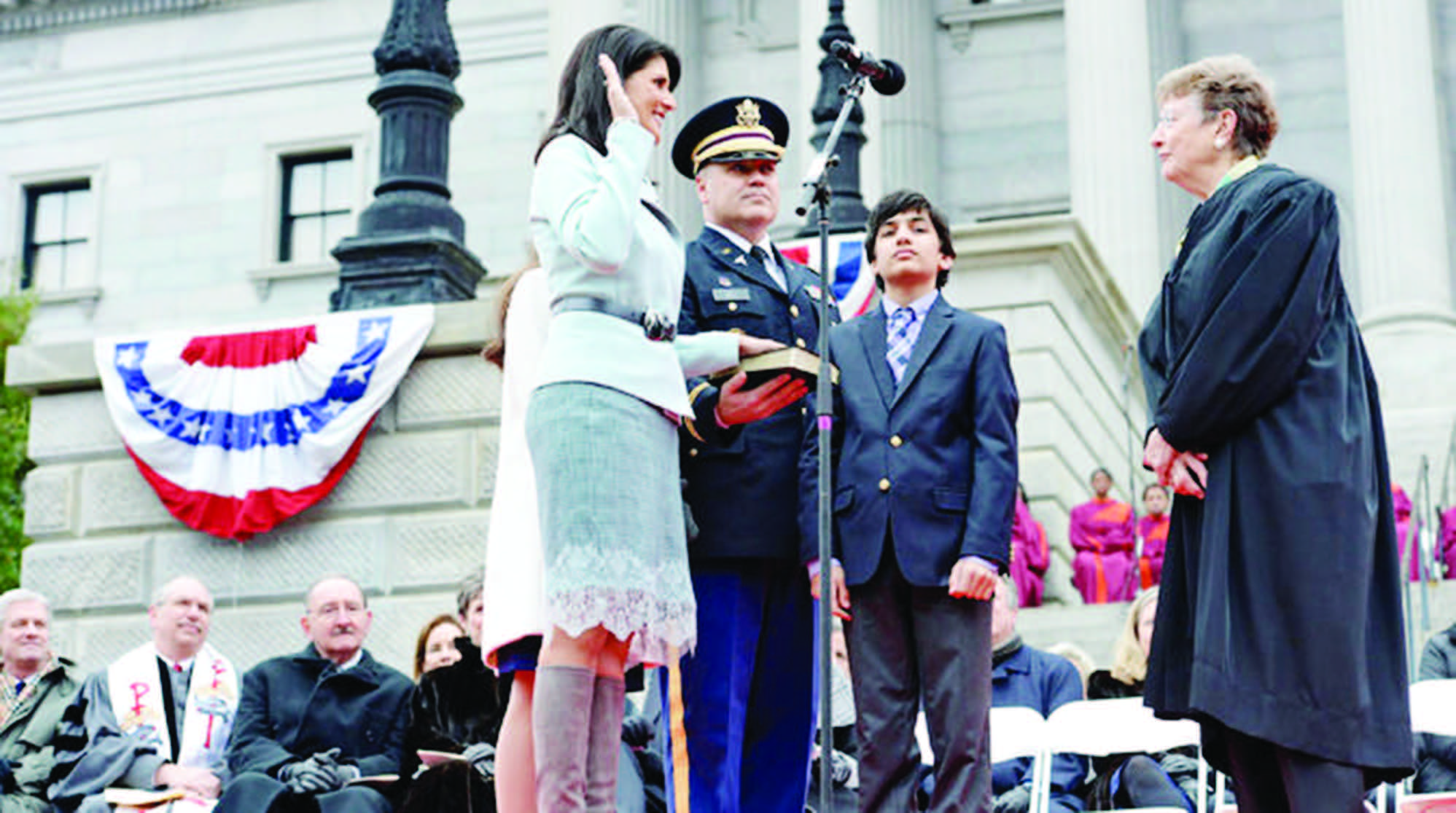 Nikki Haley in January 2015 being sworn into her second term as governor by Chief Justice Jean H. Toal, while her husbandMichael, center, and their son, Naline, watched.  Photo Credit Richard Shiro/Associated Press
