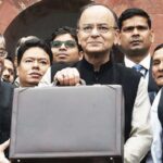 Finance Minister Arun Jaitley holding a briefcase of budget papers, with his colleagues and staff before going in to the Parliament to present the budget