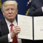 President Trump displays the travel ban order after signing it