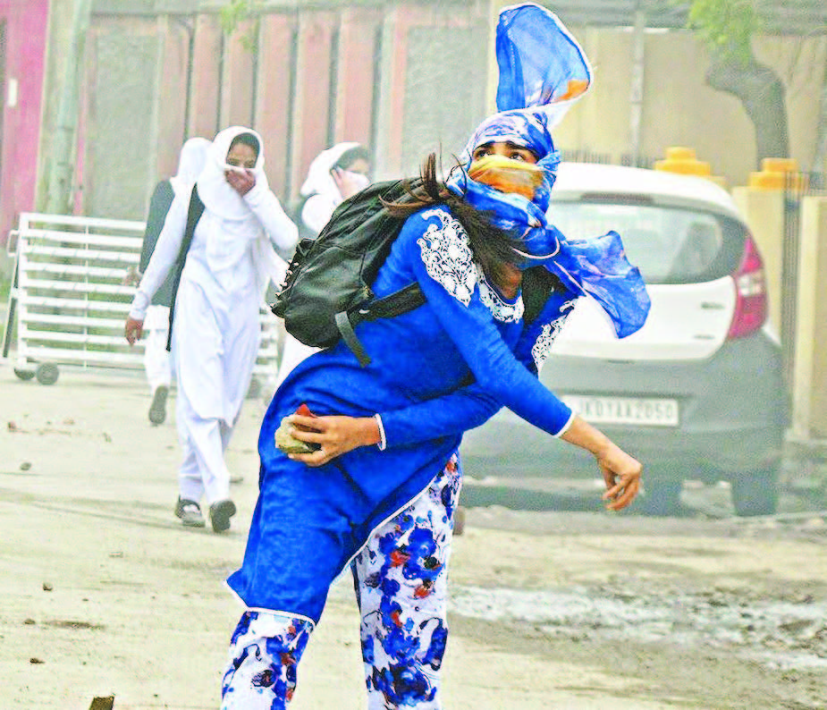 A girl student pelts a stone at security personnel during clashes near Lal Chowk in Srinagar. Photo courtesy: PTI