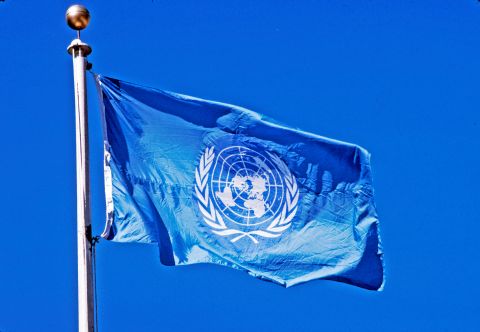 U 1 un-flag-flying-pole-blue-sky-behind-it